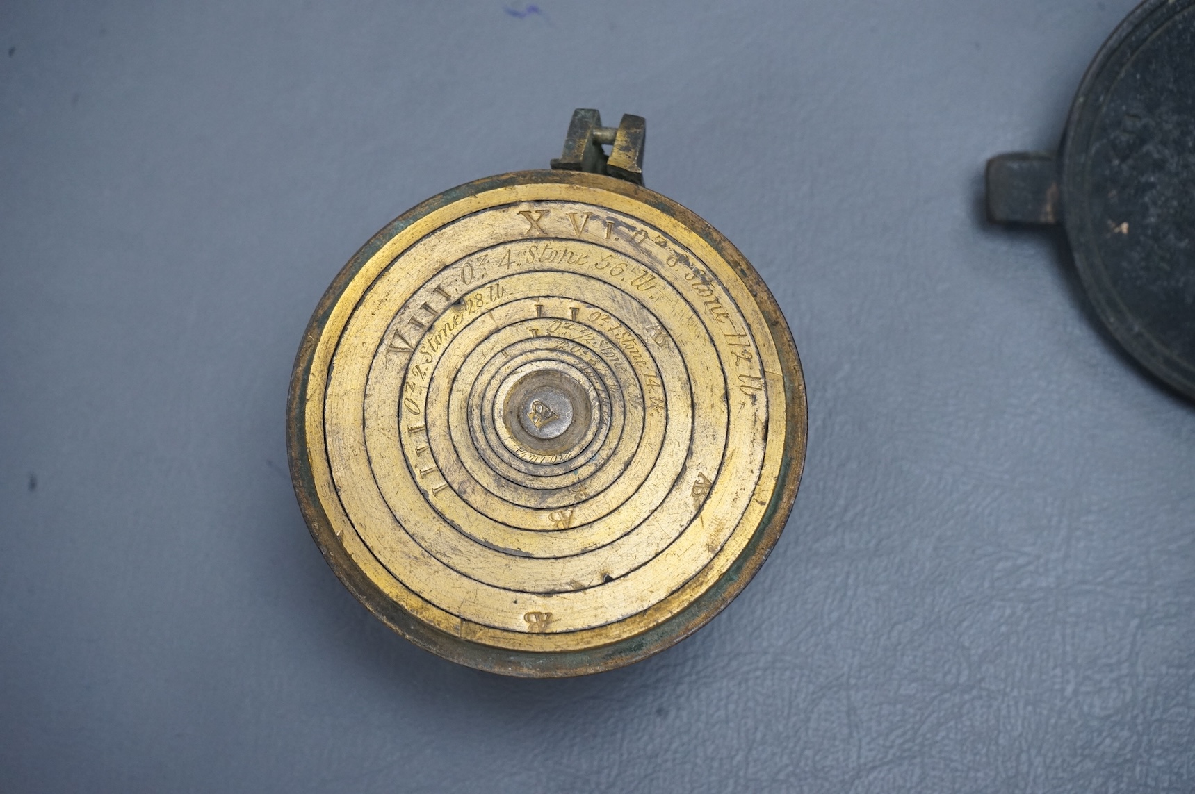 A 19th century brass nest of weights, the case with engraved inscription, 18 stone/4lb, Weeks’s Mechl. Museum, Tichborne St., 10cm wide